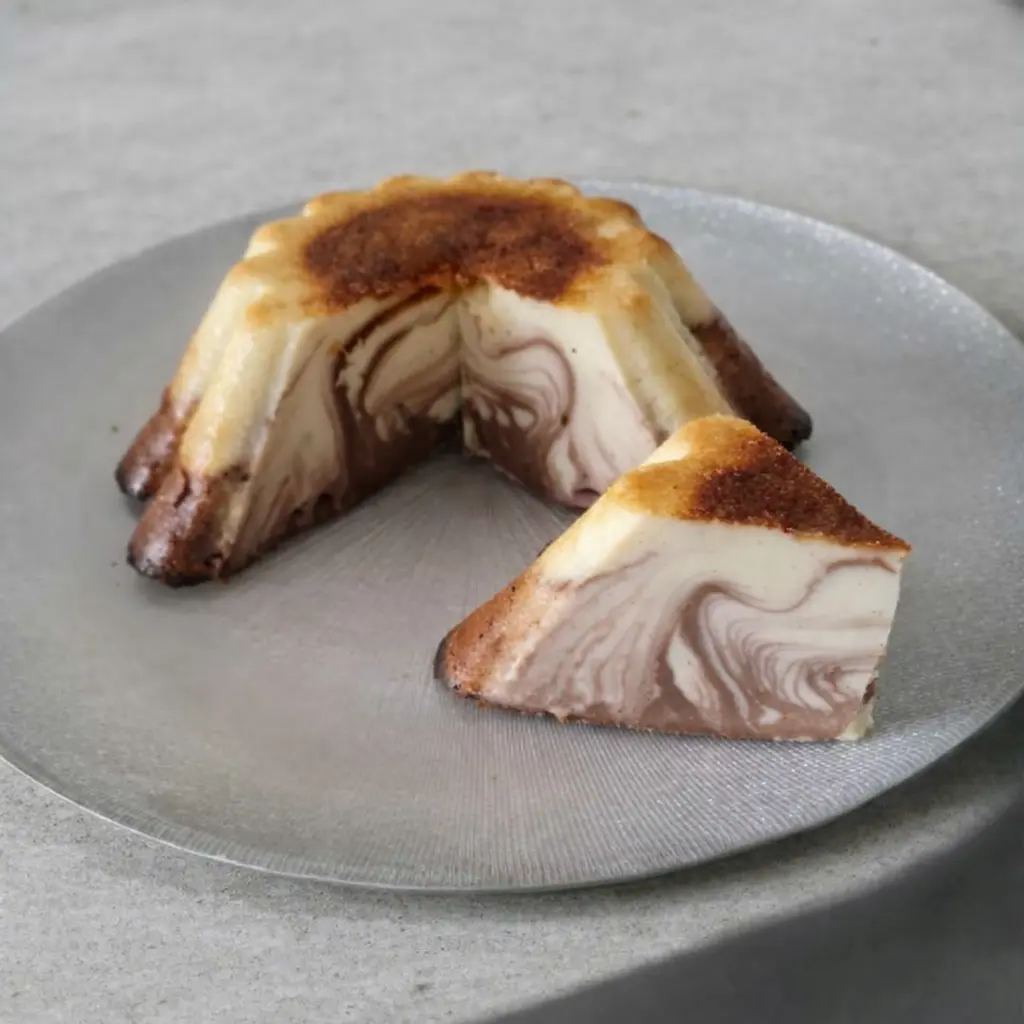 Flan marbré vanille et cacao coupé en part, présenté sur une assiette