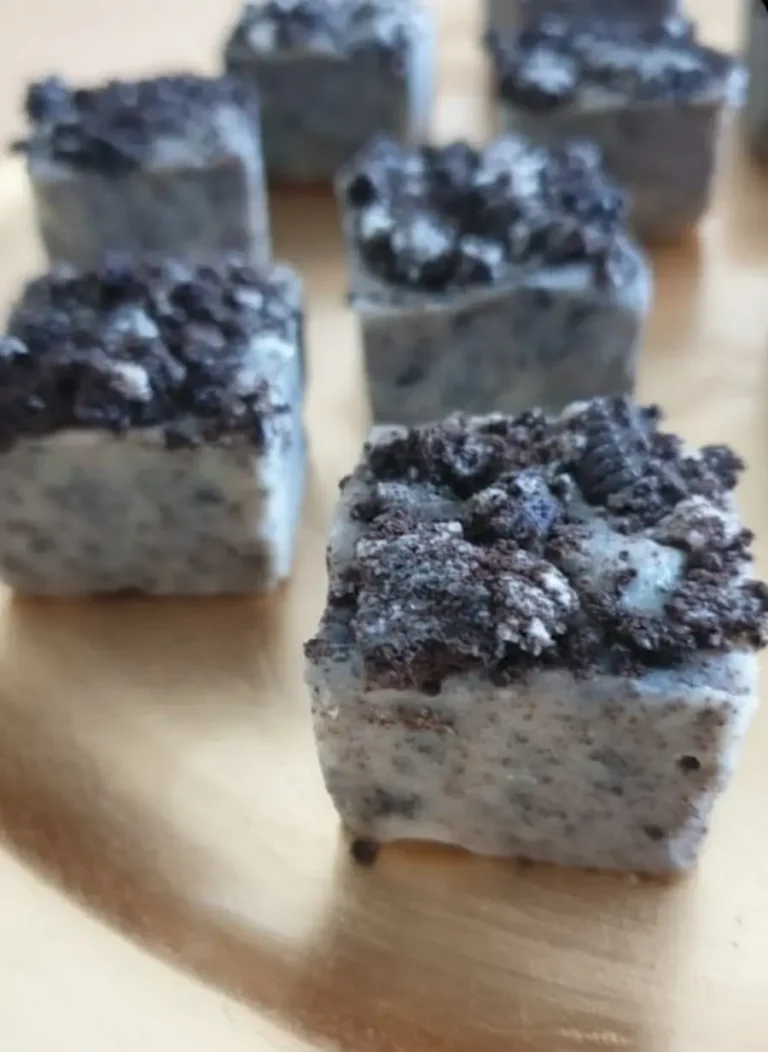 Petites bouchées carrées moelleuses avec topping chocolaté croustillant sur surface texturée