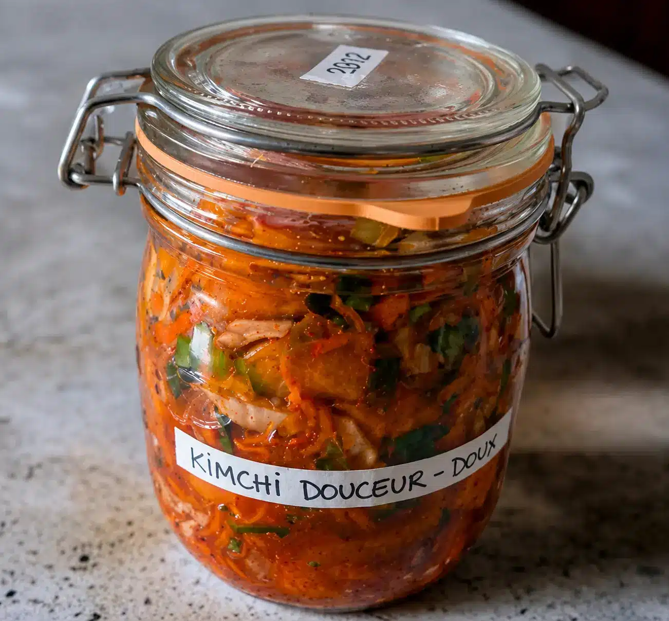 Bocal de kimchi douceur maison en fermentation naturelle sur plan de travail clair