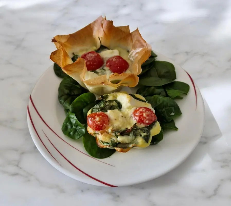 corolles filo, épinards et tomates servies en portion individuelle avec une corolle ouverte montrant la garniture au skyr et aux œufs