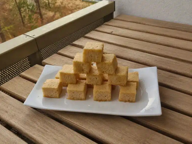 Guimauves de pommes aériennes découpées en petits cubes sur une assiette blanche